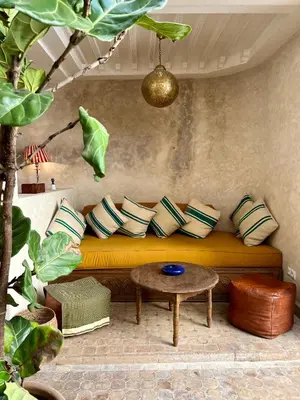 a couch with pillows and a table in a room at Riad Alena in Marrakech