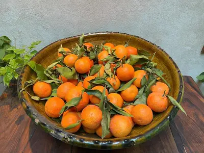a bowl full of oranges on a wooden table at Riad Alena in Marrakech