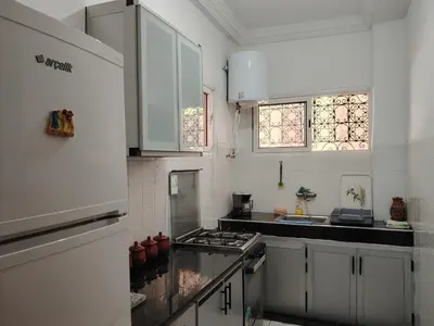 a kitchen with white cabinets and a stove top oven at Appartement résidence avec piscine in Marrakech