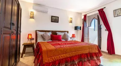 a bedroom with a large bed with red pillows at Riad 4 Jardins & Spa in Marrakech
