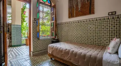 a bedroom with a bed in a room with a window at Riad 4 Jardins & Spa in Marrakech