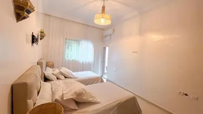 a room with two beds and a chandelier at Flair's - Families Only in Marrakech