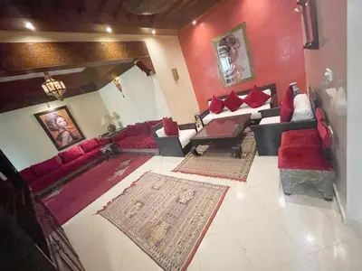 a living room with red furniture and red walls at Flair's - Families Only in Marrakech
