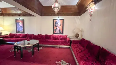 a living room with a red couch and a table at Flair's - Families Only in Marrakech