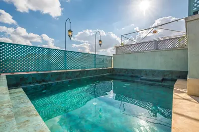a swimming pool with the sun reflecting in the water at Riad Diamond Of Marrakech & Spa in Marrakech