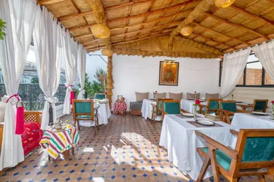 a dining room with white tables and chairs at Riad Diamond Of Marrakech & Spa in Marrakech