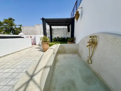 a shower on the side of a white building at Maison Meurisse Marrakech in Marrakech