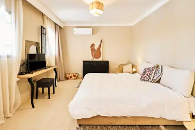 a bedroom with a bed and a desk and a television at Dar Meha in Marrakech