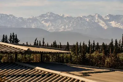 a view of a mountain range with trees and a building at Dar Meha in Marrakech