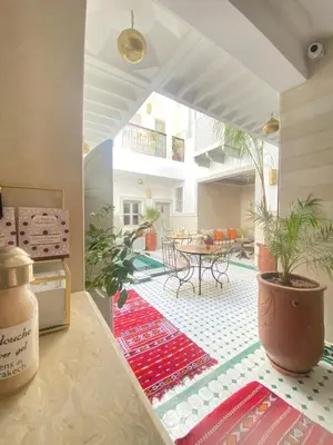 a living room with a table and a patio at Riad privatisé Magnolia in Marrakech