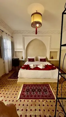 a bedroom with a large bed with a red blanket at Riad privatisé Magnolia in Marrakech