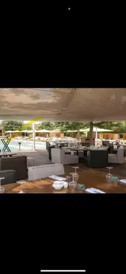 a restaurant with white tables and chairs and a largeilion at Magnifique villa avec piscine chauffée in Marrakech