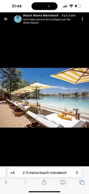 a picture of a beach with tables and umbrellas at Magnifique villa avec piscine chauffée in Marrakech