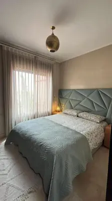 a bedroom with a large bed and a window at Magnifique villa avec piscine chauffée in Marrakech