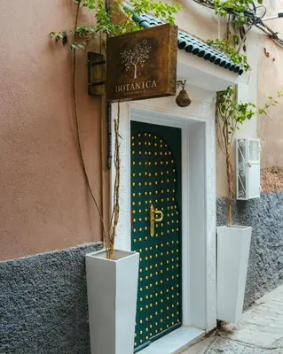 a door to a building with two potted plants at Riad Botanica in Marrakech