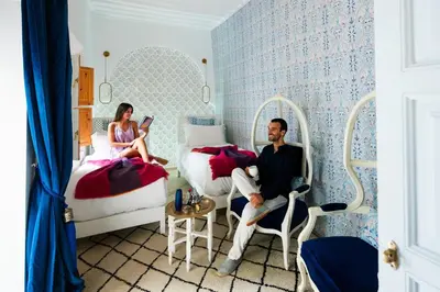a man and a woman sitting in a bedroom at Riad Botanica in Marrakech