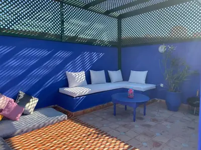 a blue room with a couch and a table at Jolie petit Riyad avec piscine belle terrasse wifi in Marrakech