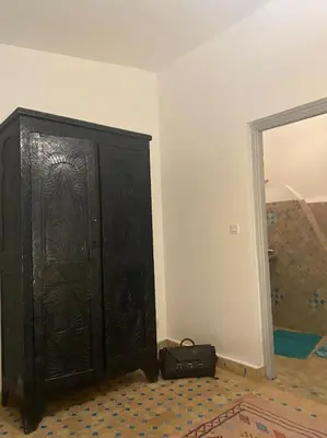 a black cabinet in the corner of a room at Jolie petit Riyad avec piscine belle terrasse wifi in Marrakech