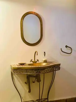 a bathroom with a sink and a mirror on the wall at Jolie petit Riyad avec piscine belle terrasse wifi in Marrakech