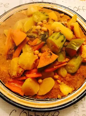 a bowl of food with vegetables on a table at Jolie petit Riyad avec piscine belle terrasse wifi in Marrakech