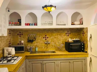 a kitchen with a sink and a microwave at Jolie petit Riyad avec piscine belle terrasse wifi in Marrakech