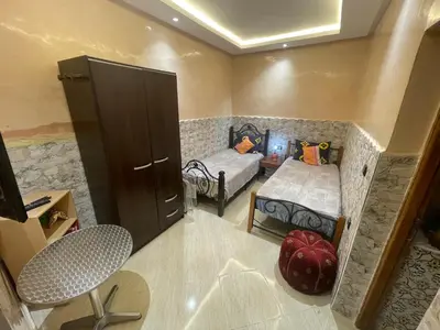 a small room with two beds and a cabinet at Dar Chrif in Marrakech