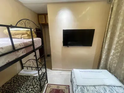 a room with two bunk beds and a flat screen tv at Dar Chrif in Marrakech