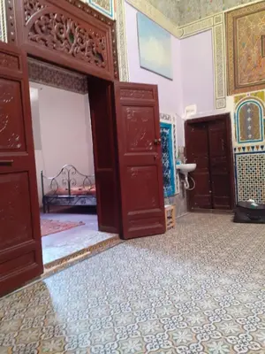 a room with two open doors and a bed at Maison authentique centre médina in Marrakech