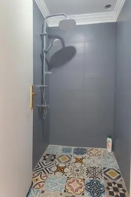 a bathroom with a shower and a tile floor at Villa Kalthoum in Marrakech