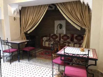 a living room with a couch and a table and chairs at riad rose eternelle in Marrakech
