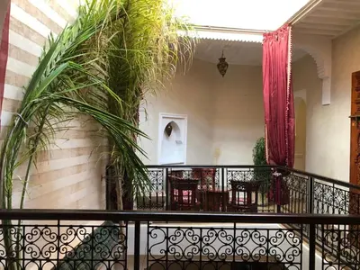 a balcony with tables and chairs and plants at riad rose eternelle in Marrakech