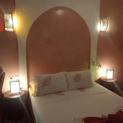 a bedroom with a white bed with two lamps at riad rose eternelle in Marrakech