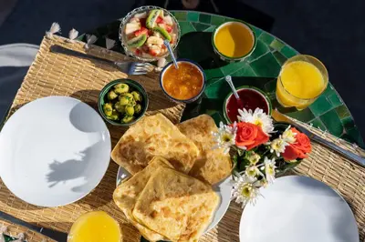 a table with a plate of food and some orange juice at Riad Espoir Spa Logement entier in Marrakech