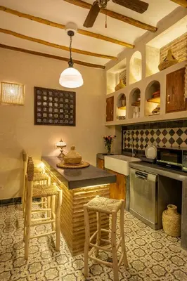 a kitchen with a counter and some stools in it at Riad Espoir Spa Logement entier in Marrakech