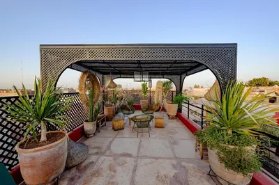 a patio with potted plants and a table on a balcony at RIAD DAR C in Marrakech
