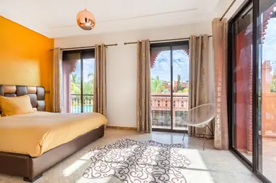 a bedroom with a bed and a large window at Magnifique villa de 320 m2 avec 2 piscines in Marrakech