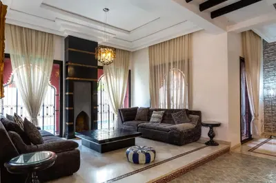 a living room with a couch and a table at Magnifique villa de 320 m2 avec 2 piscines in Marrakech