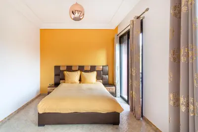 a bedroom with a bed and a yellow wall at Magnifique villa de 320 m2 avec 2 piscines in Marrakech