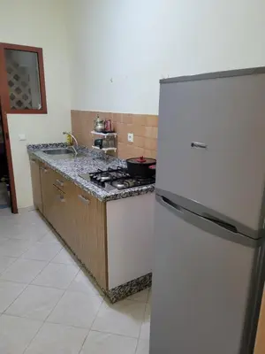 a kitchen with a white refrigerator and a stove at Basic appartement avec Parking in Marrakech