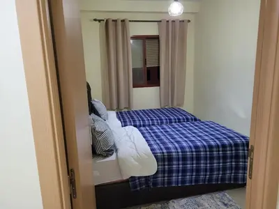 a bedroom with a bed with a blue plaid blanket at Basic appartement avec Parking in Marrakech