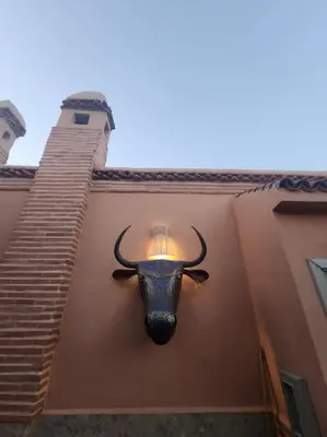 a light on a building with a bull head on it at Riad M. Jacuzzi - Piscine Arty/Cosy - Privatif in Marrakech