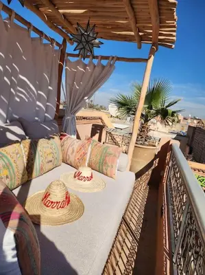 a table with hats sitting on a balcony at Riad M. Jacuzzi - Piscine Arty/Cosy - Privatif in Marrakech