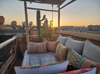 a couch sitting on top of a balcony with a cactus at Riad M. Jacuzzi - Piscine Arty/Cosy - Privatif in Marrakech