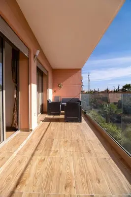 an empty balcony with a wooden floor in a house at pearl garden marrakech in Marrakech