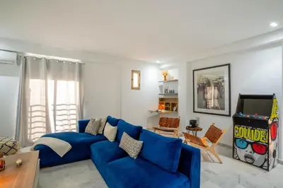 a living room with a blue couch and a video game at NEW ! Unique Equipped Flat in the Heart of Marrakech in Marrakech