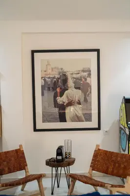 a framed picture on a wall with two chairs at NEW ! Unique Equipped Flat in the Heart of Marrakech in Marrakech