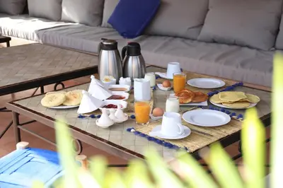 a coffee table with breakfast foods and drinks on it at Riad Noor Charana in Marrakech