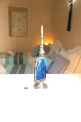 a glass bottle on a table in a bedroom at RIAD TAZZORI in Marrakech
