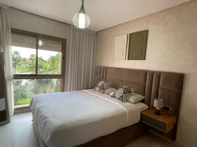 a bedroom with a large bed and a window at Appartement de luxe Prestigia Opale in Marrakech