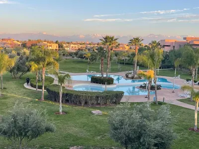 an aerial view of a resort pool with palm trees at Appartement de luxe Prestigia Opale in Marrakech